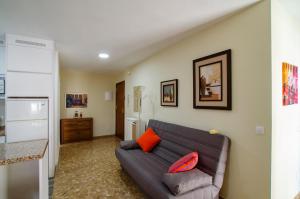 a living room with a brown couch and orange pillows at El Atico de Andrea in Torre del Mar
