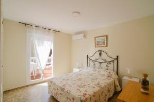 a bedroom with a bed and a table and a window at El Atico de Andrea in Torre del Mar