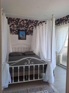 a bedroom with a bed with white curtains at gîte en campagne Lamégritnière in Mégrit +96 photos