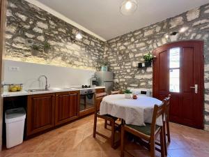 a kitchen with a table and a sink and a stove at Stone House Mia in Premantura