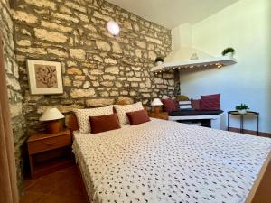 a bedroom with a bed and a stone wall at Stone House Mia in Premantura