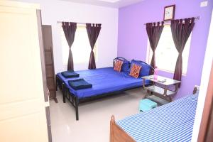two beds in a room with purple walls and windows at Tranquil Garden terrace in the heart of city in Bhubaneshwar +4 photos