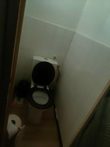 a small bathroom with a black toilet in a stall at Maison centre-ville in Capdenac-Gare
