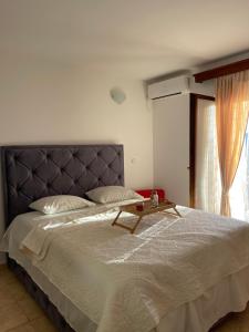 a bedroom with a large bed with a table on it at Apartmani Gazivode in Budva