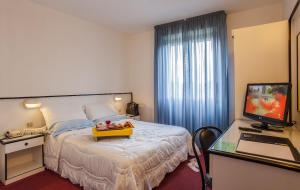 una camera d'albergo con letto e TV di Hotel Quadrifoglio a Cagliari