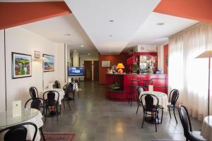 Un restaurante con mesas y sillas y un bar. en Hotel Quadrifoglio, en Cagliari