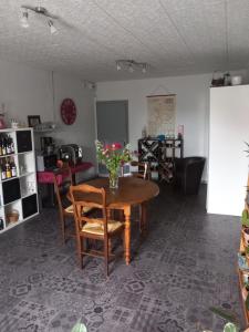 a dining room with a table with flowers on it at Relais de la Mothe LA SUITE in Vrécourt