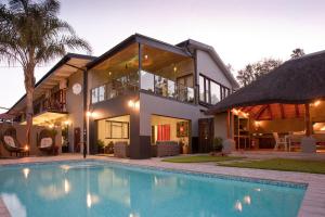 a house with a swimming pool in front of a house at Miles B&B Guest House in Oudtshoorn