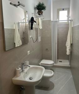 a bathroom with a sink and a toilet and a shower at Five Apartment B&B in Licata