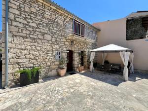 a patio with a table and a white umbrella at Stone House Mia in Premantura