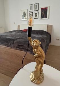a lamp on a table in front of a bed at Ferienwohnung Am Kiessee Birkwitz in Pirna