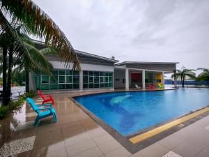 a swimming pool with a chair and a house at INS Pavillion by irainbow in Ipoh