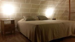 ジノーザにあるNel Vicolettoのベッドルーム1室(ベッド1台、ランプ2つ、テーブル2台付)
