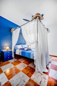 Un dormitorio con una cama con cortinas blancas y un sombrero. en Apartamento Carlos , Lomas de Cabo Roig area,2 bedroom,2 terraces,swimming pool, en Orihuela Costa