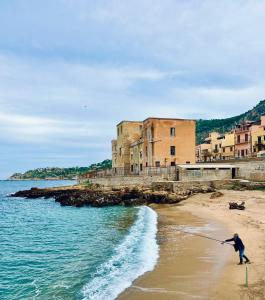 a man is standing on a beach with a pole at Oltremare Suite N37 Villa fronte mare con spa privata giardino vista panoramica e wifi gratuito in Bagheria
