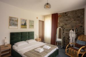 Un dormitorio con una cama grande y una pared de piedra. en Mood Hotel Kazbegi, en Kazbegi