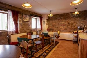 Un restaurante con mesas y sillas y una pared de piedra. en Mood Hotel Kazbegi, en Kazbegi