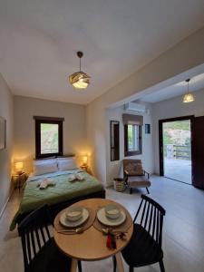 a bedroom with a bed and a table and chairs at Limnionas Apartments in Xorychti
