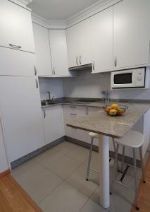 Una cocina con una mesa con un bol de fruta encima. en MARALES Sanxenxo, en Sanxenxo 5 fotos más