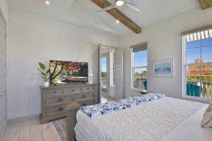 a bedroom with a bed and a dresser and windows at Rise and Shine Beach House with Ocean Views and Pointe West Resort Pools in Galveston +42 photos