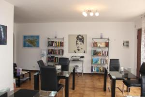 a living room with a table and chairs and bookshelves at B&B Villa Adriana in San Leone
