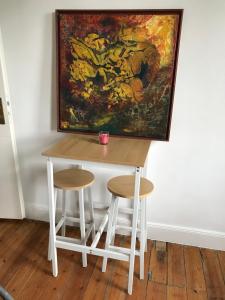 a table and two stools in front of a painting at Ferienwohnung in Bleckede in Bleckede