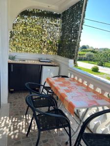 a balcony with a table and chairs and a window at Kastrati Apartments in Ulcinj