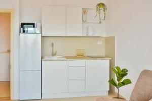 a kitchen with white cabinets and a sink at Apartman ELENA in Senj