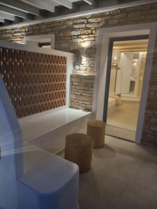 a room with a stone wall and a table and stools at Golden Star in Ios Chora