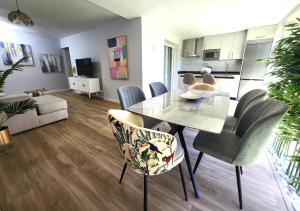 a living room with a dining room table and chairs at ANSA Beach Apartments - Cabopino, Marbella - Garden level in Cabopino
