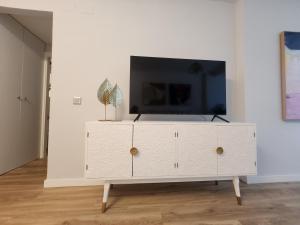 a white cabinet with a tv on top of it at ANSA Beach Apartments - Cabopino, Marbella - Garden level in Cabopino