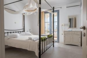 1 dormitorio con cama con dosel negra y baño en Iliada Villas, en Agios Prokopios 98 fotos más