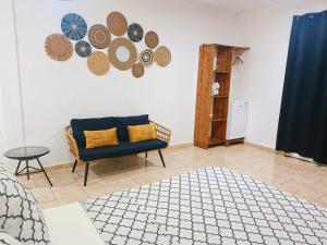 a living room with a blue couch and plates on the wall at Ô'JASMIN in Mamoudzou