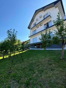 un bâtiment avec un arbre devant lui dans l'établissement Apartment BORICI, à Bihać