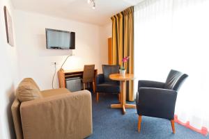 a living room with a couch and chairs and a table at Hotel de Burg in Domburg