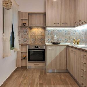 a kitchen with wooden cabinets and a stainless steel oven at Laurel LK Houses in Kritinia Rhodes in Kritinía +38 photos