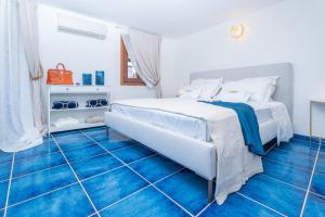 a bedroom with a white bed and blue tile floors at Villa Graya in Porto Istana