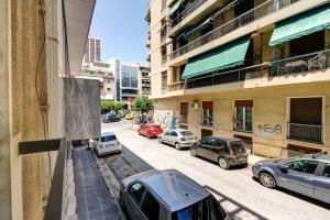 雅典Classy and stylish apartment next to Hilton的街道上停满了停在建筑物旁边的汽车