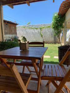 a wooden picnic table and two chairs on a patio at Suíte Nativa - Flecheiras in Flecheiras