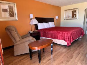 a hotel room with a bed and a chair at Stamford INN in Stamford