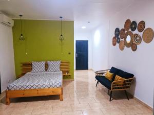 a bedroom with a bed and a chair in a room at Ô'JASMIN in Mamoudzou