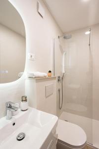 Un baño blanco con lavabo y ducha. en Luxury City Center House, en Split