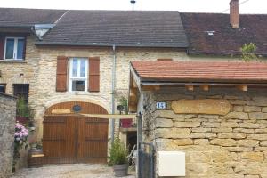 a house with a wooden gate and a stone wall at Chez Flo in Sainte-Agnès