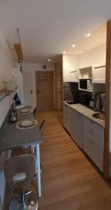 a kitchen with white cabinets and a wooden floor at Chez Flo in Sainte-Agnès +5 photos
