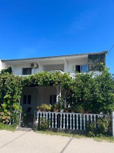 a white house with a gate and a fence at Kastrati Apartments in Ulcinj