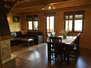 a dining room with a table and a couch at Dzika Cisza DOMEK CAŁOROCZNY in Olchowiec