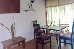 a dining room with a glass table and chairs at Casa de huéspedes Maturin 3 hab in Maturín