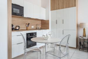 a white kitchen with a table and chairs at Hyper centre vue bords Loire #confort #luxe in Tours +18 photos