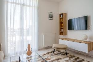 a white living room with a tv and a chair at Hyper centre vue bords Loire #confort #luxe in Tours
