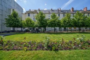 a park with flowers in front of a building at Hyper centre vue bords Loire #confort #luxe in Tours